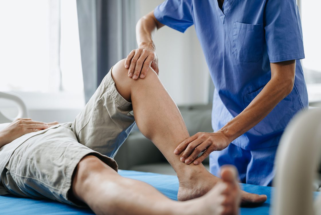 Physical therapist examining patient's leg